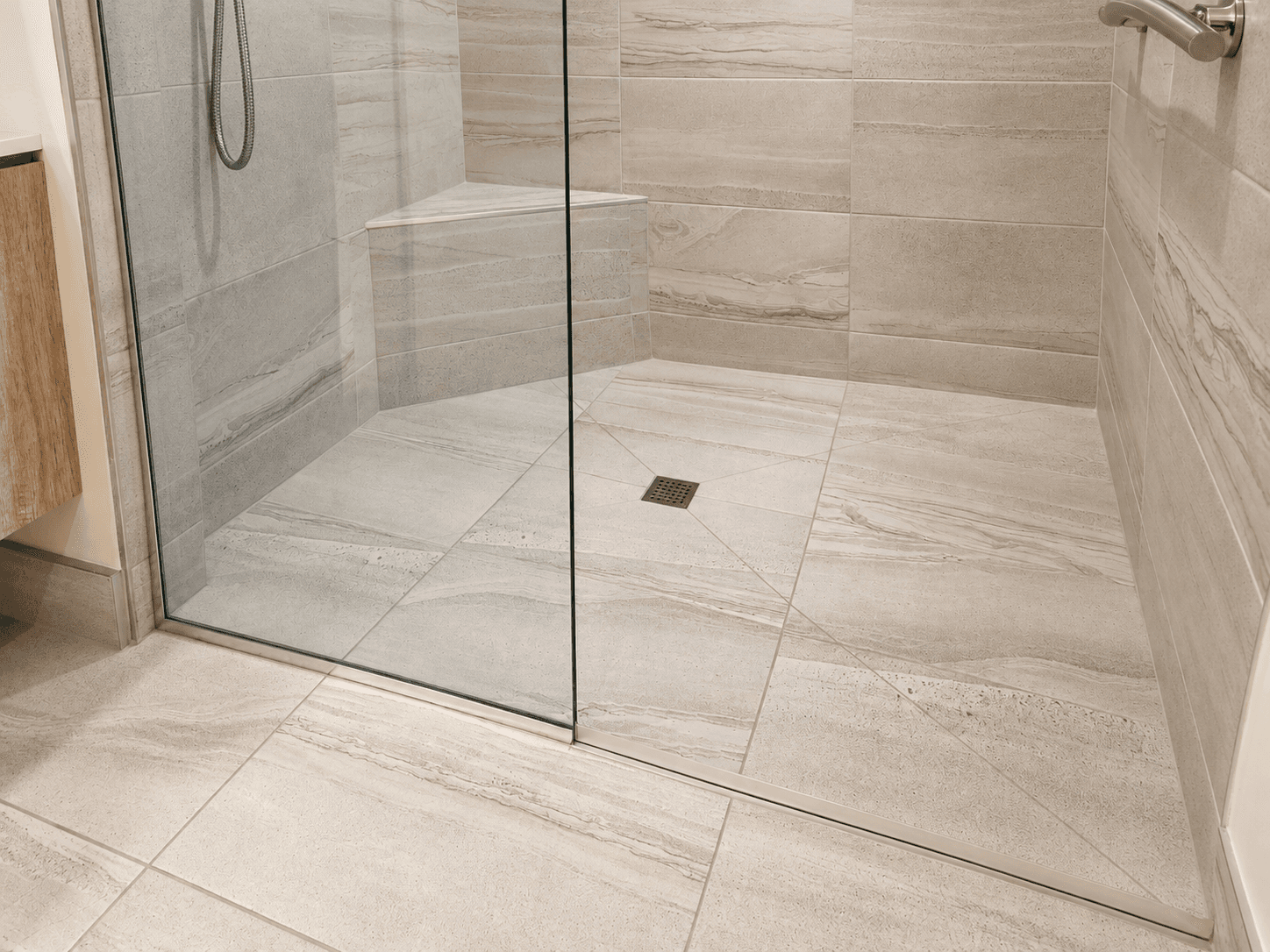 Large-format stone tiles across a shower wall and floor